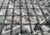 $100M Mirage: Bank Duped By Paperwork? pile of us dollar bills with a ten-dollar note on top