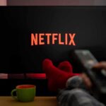 Netflix Paywall Ambushes GTA VI Hype TV screen with Netflix logo and person holding remote