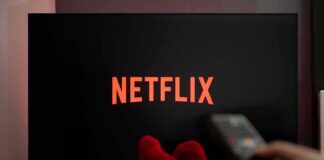 TV screen with Netflix logo and person holding remote