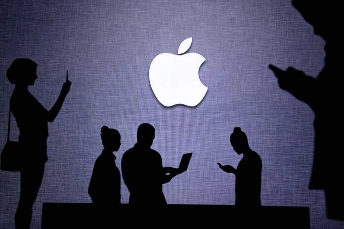 shutterstock_1757133131 Apple logo with silhouettes of people using devices