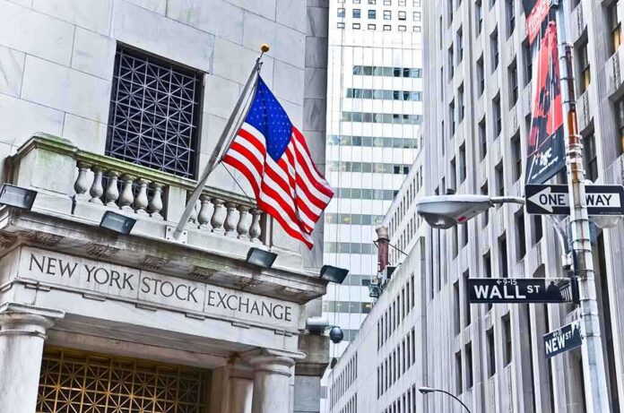 shutterstock_240002407 Facade of the New York Stock Exchange with an American flag and Wall Street sign