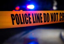 police tape with patrol car lights in background