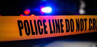 police tape with patrol car lights in background