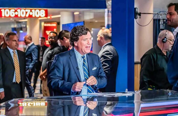 shutterstock_2423149155 news anchor at a studio desk with crew and onlookers