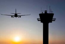 Controller Exodus Guts Homeland Readiness Airplane approaching runway near airport control tower at sunset