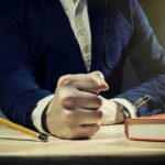Man in suit slams fist on desk with flying paperclips