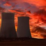 Nuclear Lifeline CUT — Five Days of Panic Silhouette of cooling towers against a vibrant sunset sky