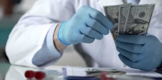Gloved hands in a lab coat counting US dollar bills