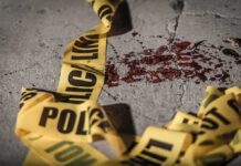 Crime scene tape near blood on pavement