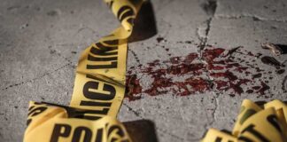 Crime scene tape near blood on pavement