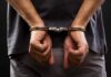 person with hands cuffed behind back