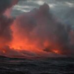 NOAA Rings Alarm: Ocean Heat Off Charts Volcanic steam plume over dark ocean at dusk