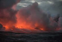 NOAA Rings Alarm: Ocean Heat Off Charts Volcanic steam plume over dark ocean at dusk