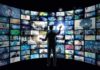 10% Ad Surcharge Raises Legal Alarms Person interacting with curved wall of digital screens