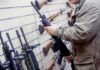 DOJ Intercepts Rifle Before Alleged ISIS Attack Person examining a black rifle in a gun store