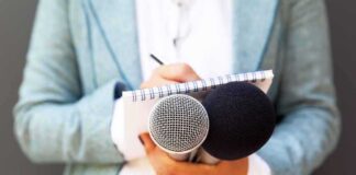 Journalist holding microphones and notepad