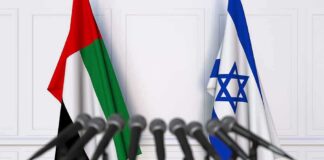 UAE and Israel flags behind microphones