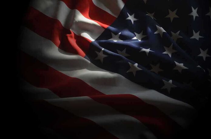 shutterstock_1271957638 United States flag with stars and stripes in dramatic lighting