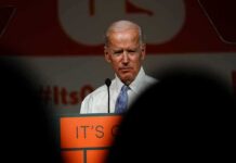 older man at a podium speaking on stage