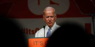 older man at a podium speaking on stage