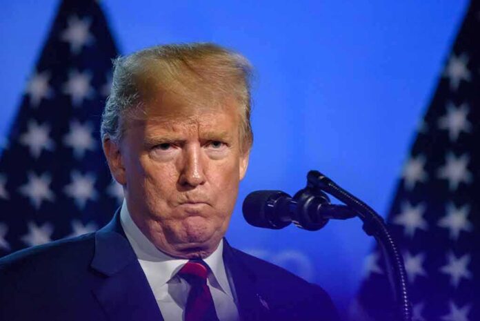 Donald Trump at a podium with U.S. flags in the background