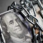 US dollar bills wrapped in metal chains