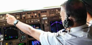 Pilot adjusting controls in an airplane cockpit