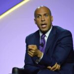 Booker Explodes: Trump ‘Criminal’ Warning Cory Booker speaking on stage in a suit and tie