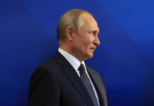 Putin’s Gambit: NATO Fracture Play? man in suit in profile against blue background