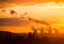 Grid Twist In India – Coal Loses Ground Power plant cooling towers emit smoke at sunset