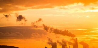 Power plant cooling towers emit smoke at sunset