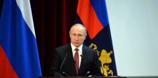 speaker at podium with flags in background