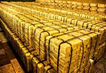 Stacks of gold bars strapped together in a vault
