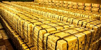 Stacks of gold bars strapped together in a vault