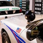 Border Stop Unmasks Years-Long Abduction Police patrol cars parked indoors with cityscape backdrop