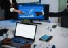 Cyber Supercharge Threatens Pensions—G20 on Edge Business team pointing at stock chart on monitor during meeting