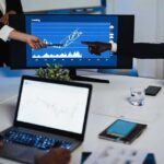 Cyber Supercharge Threatens Pensions—G20 on Edge Business team pointing at stock chart on monitor during meeting
