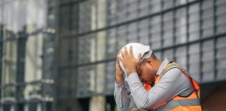 construction worker sitting with head in hands