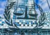 Sanctions Hammer ICC – Trump Chokes Money Pipeline Scales of justice emblem on glass facade of modern office building