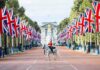 mounted guard on white horse along flag-lined boulevard