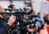 Trump Arch Showdown Explodes — Park Service Plows Ahead Video cameras on tripods at a media event