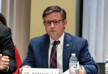 Speaker Slams Brakes – Hegseth Safe…For Now A public official speaking at a meeting with a nameplate in front of him