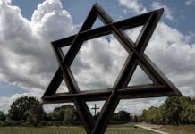 Large Star of David sculpture in a park under cloudy sky