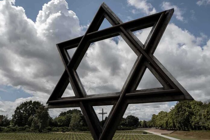 Large Star of David sculpture in a park under cloudy sky