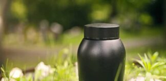 Black urn placed on greenery outdoors