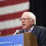Massive Money Blitz Hits Michigan elderly man speaking at a podium