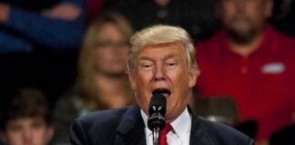 Donald Trump speaking at a podium with a microphone