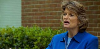 Lisa Murkowski speaking at an outdoor press conference with microphones in front