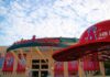 Kroenke’s $4B Power Grab Stuns MLB Angel Stadium entrance with large red baseball cap sculpture
