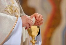Communion Uproar: Who Actually Gets Barred? Priest holding a communion wafer over a gold chalice